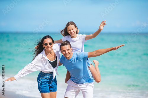 Family of three on the beach having fun together