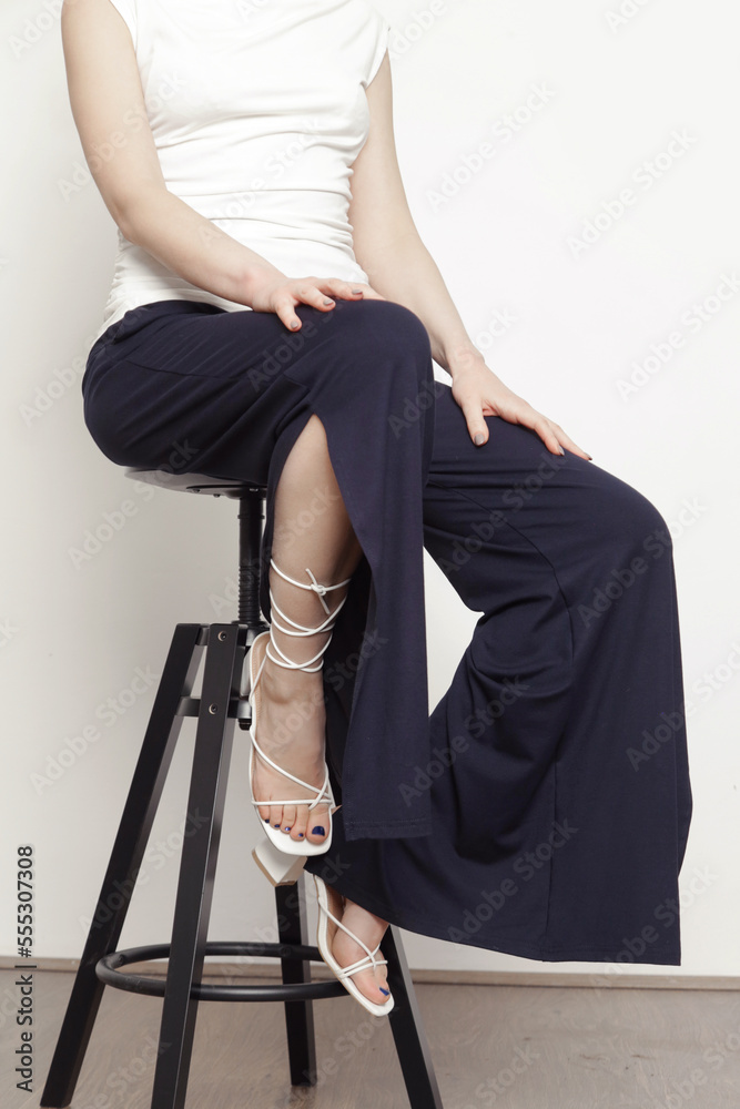 Serie of studio photos of young female model wearing simple comfortable outfit, organic cotton white shirt and black trousers