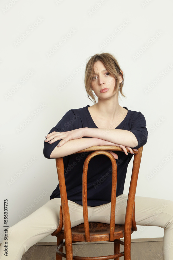 Serie of studio photos of young female model wearing simple comfortable outfit, organic cotton blue blouse and white trousers Serie of studio photos of young female model wearing simple comfortable outfit, organic cotton blue blouse and white trousers