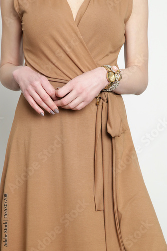 Serie of studio photos of young female model in beige viscose wrap dress.