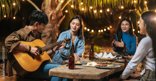 Portrait of Happy Asian group of friends having fun to music dining and drinking together outdoor - Happy friends group toasting beers  - People  food  drink lifestyle  new year celebration concept.