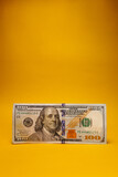 100 dollar banknote with yellow background