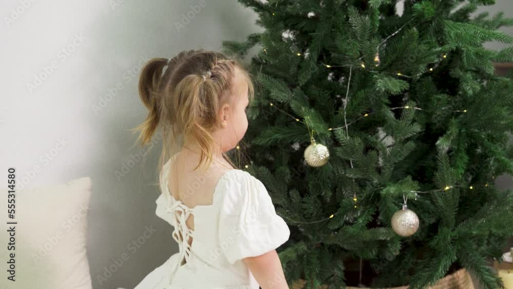 A happy little girl bouncing on the couch, rejoicing at the approach of Christmas A happy little girl bouncing on the couch, rejoicing at the approach of Christmas