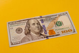 100 dollar banknote with yellow background