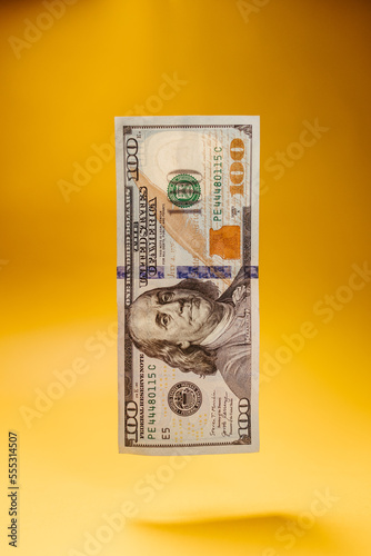 100 dollar banknote with yellow background