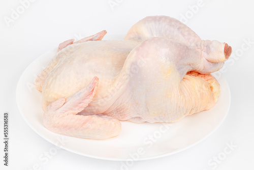 Whole raw chicken on a white plate. Diet meat.