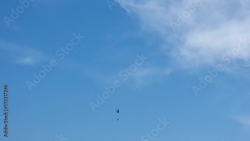 An invisible skydiver descending on a parachute