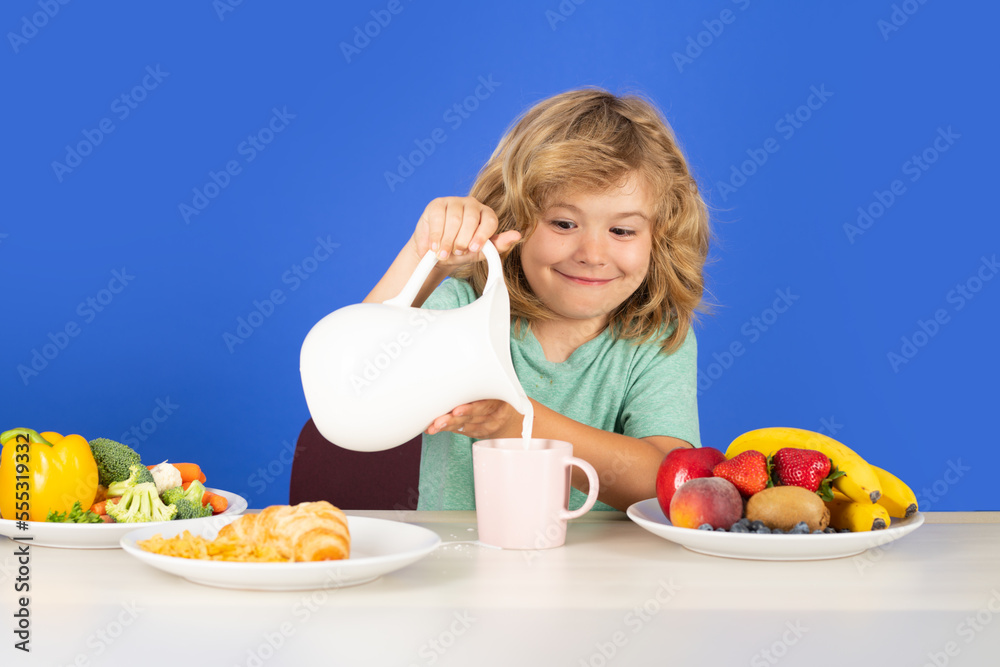 Cute kid drinking milk on blue background. Kid with dairy milk.