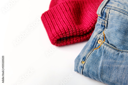 blue cotton jeans and raspberry wool sweater on white, banner concept, close-up