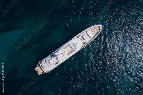 Big White Mega yacht is anchored on clear water, top view. Super yachts in the sea top view.
