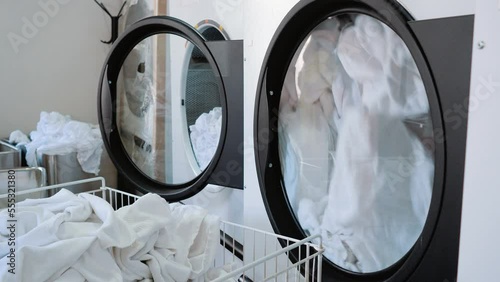 Laundry. Large washing machines with white linen. Dry cleaning