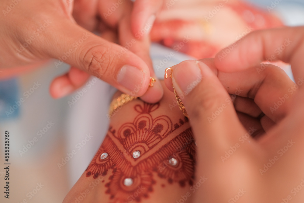 The groom put the wedding bracelet to the bride during solemnization ceremony. Family and happiness concept. The groom put the wedding bracelet to the bride during solemnization ceremony. Family and happiness concept.