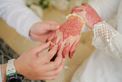 Obraz na płótnie Malay Wedding Couple Putting A Ring On Hand.Selective Focus And Shallow DOF. w salonie