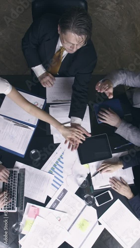 Top view of business people forming hands stack in meeting room. Vertical video