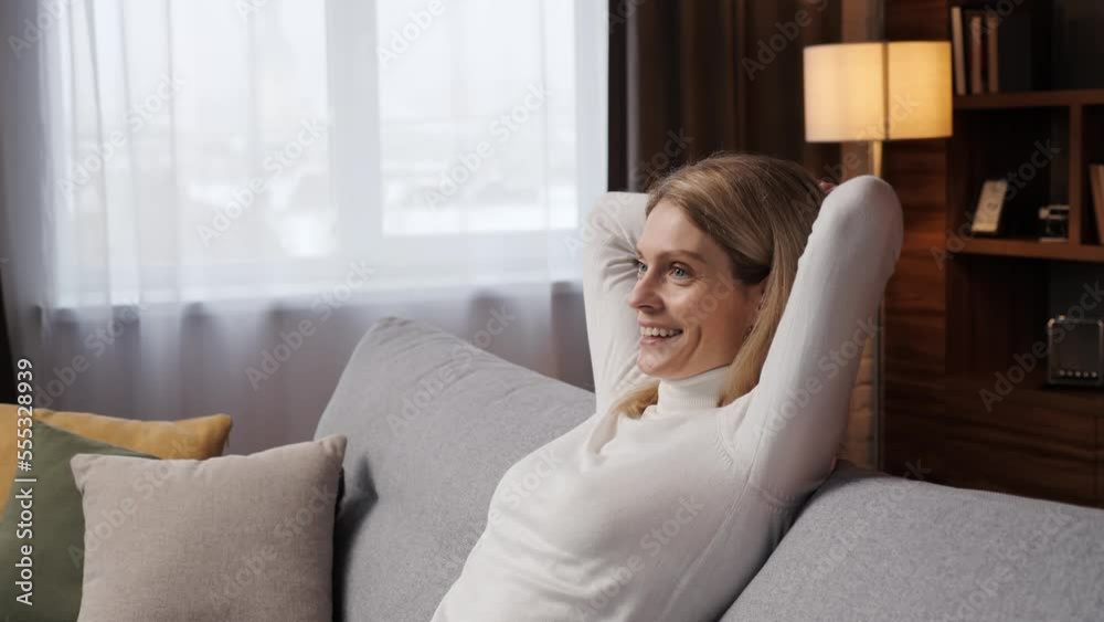 Smiling contented attractive woman relaxing on sofa, taking deep breath of fresh air, holding hands on head healthy calm lady relaxing on comfortable sofa, not feeling stressed in living room at home. Smiling contented attractive woman relaxing on sofa, taking deep breath of fresh air, holding hands on head healthy calm lady relaxing on comfortable sofa, not feeling stressed in living room at home.