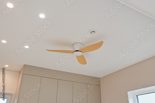 It is a ceiling ceiling fan finished with wood material