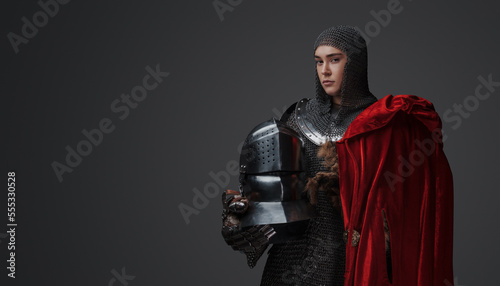 Stampa su tela Studio portrait of determined female knight dressed in chainmail against grey background
