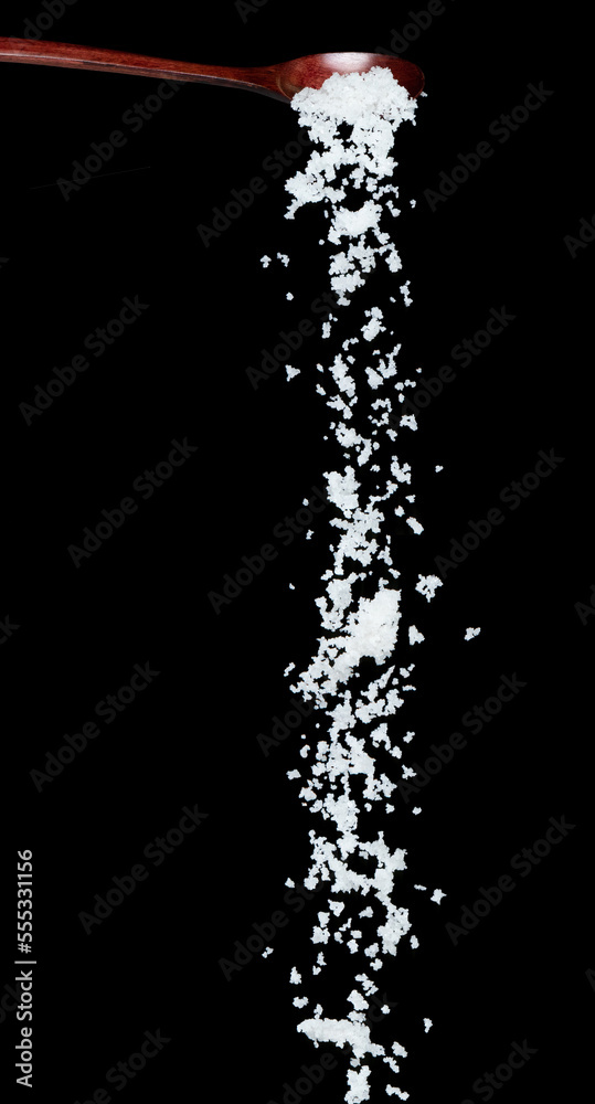 Obraz premium Salt fall, crystal white grain peanuts explode abstract cloud fly from wooden spoon. Beautiful complete seed salt, food object design. Selective focus freeze shot black background isolated