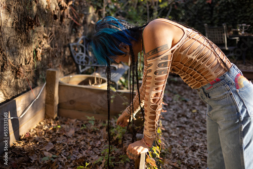 Bilde på lerret indigenous non-binary artist with blue hair and braids in the garden