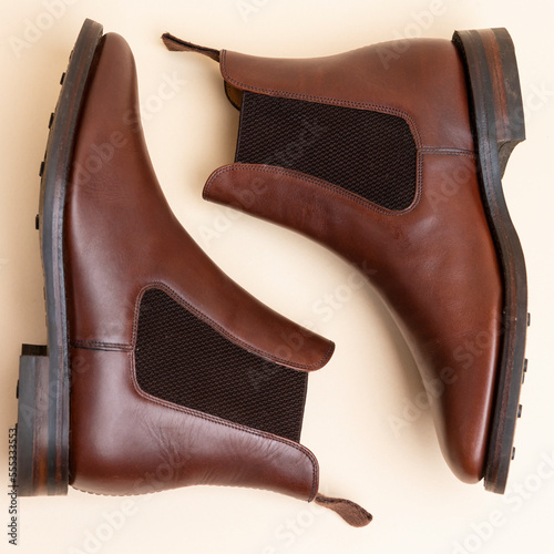 Closeup of Pair of Classic Leather Chealsea Boots As Still Life Concepts Placed Near One Another Over Beige Background.