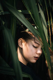 Portrait of asian women with green leaf. Beautiful asian girl looking at camera. Close up of face asian women with palm leave.