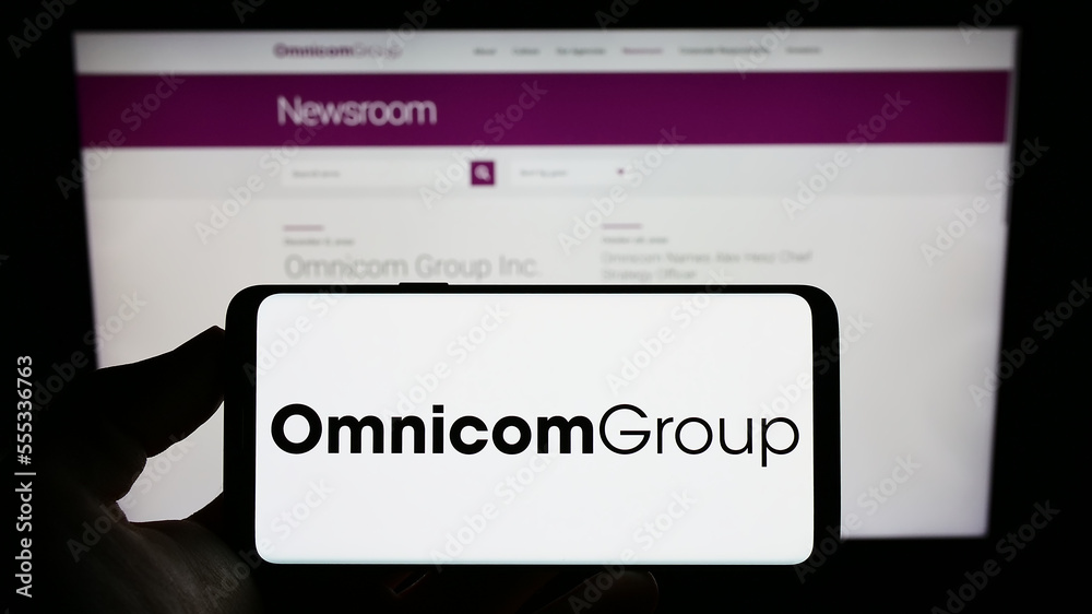 Stuttgart, Germany - 12-10-2022: Person holding cellphone with logo of US media  company Omnicom Group Inc. on screen in front of business webpage. Focus on  phone display. foto de Stock | Adobe Stock