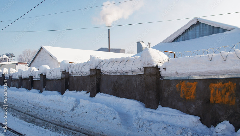 Industrial zone. Factory. Fence with barbed wire. Winter. Ust-Kamenogors (kazakhstan) Industrial zone. Factory. Fence with barbed wire. Winter. Ust-Kamenogors (kazakhstan)