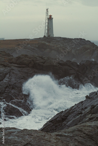 Stokksnes lighthouse on cliff at storm landscape photo. Beautiful nature scenery photography with sky on background. Idyllic scene. High quality picture for wallpaper, travel blog, magazine, article