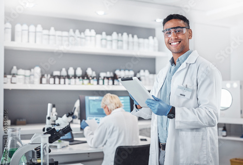 Science, tablet and portrait of a male scientist doing research with technology in a medical laboratory. Happy, smile and man chemist or biologist working on a mobile device in a pharmaceutical lab. photo