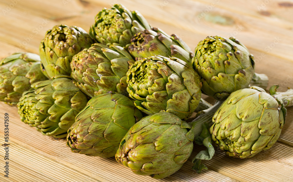 Fototapeta premium Fresh organic artichoke flowers on wooden table