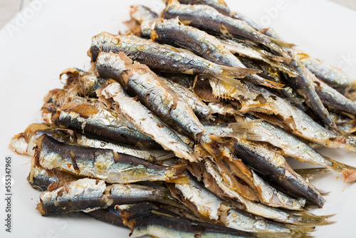 Healthy food. Delicious sardines baked in oven served on white plate..