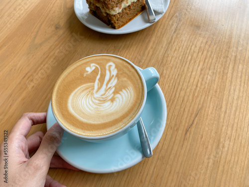 delicious and beautiful latte art coffee in blue cup with carrot cake slice for brunch and breakfast