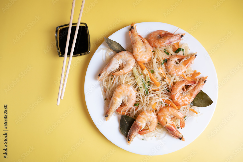 Funchosa salad with shrimp and soy sauce on a yellow background Funchosa salad with shrimp and soy sauce on a yellow background