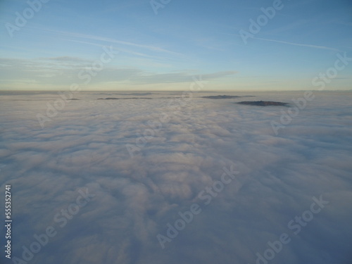 flight above clouds through the cloudy sky