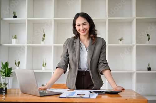 Successful and confident millennial Asian businesswoman or female CEO at her office desk.