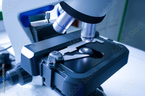 Close-up shot of microscope with metal lens at laboratory. research chemistry equipment scope biotechnology