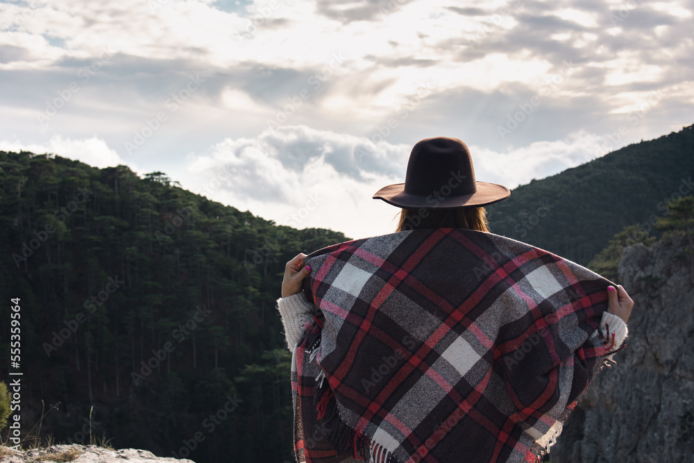 Woman hiker enjoying mountain view alone outdoors.
Travel and outdoor activities, healthy lifestyle. Beautiful view of the mountains.