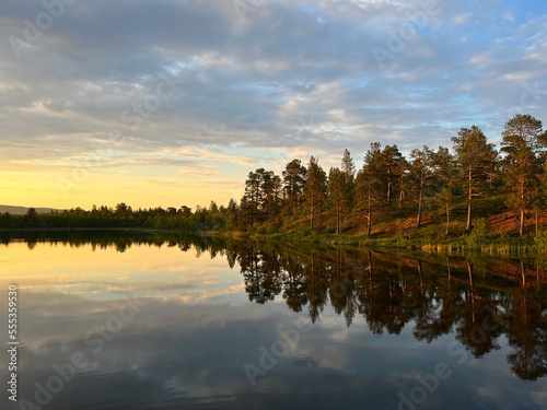 early morning lake view, trees silhouettes reflection on the lake surface, forest lake before the sunrise