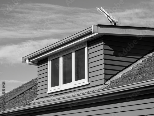 Fotografi Shed roof dormer loft with white window and clay tiles