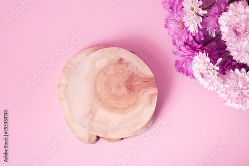 Wooden podium or pedestal with chrysanthemum flowers top view. Mockup for your cosmetic products