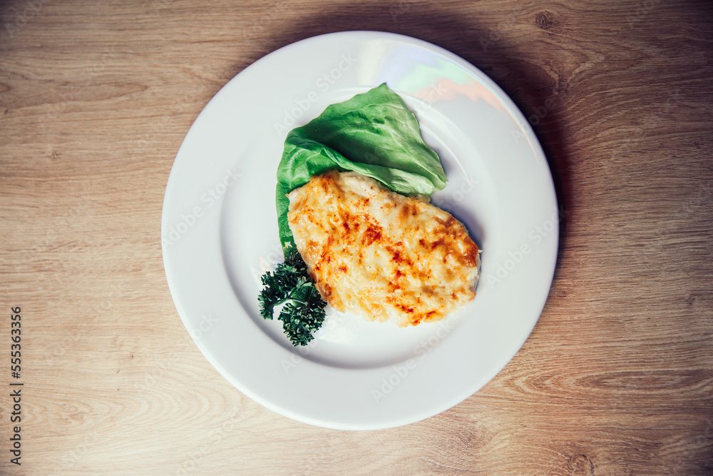 top view . chicken fillet in cheese in a white plate top view . chicken fillet in cheese in a white plate