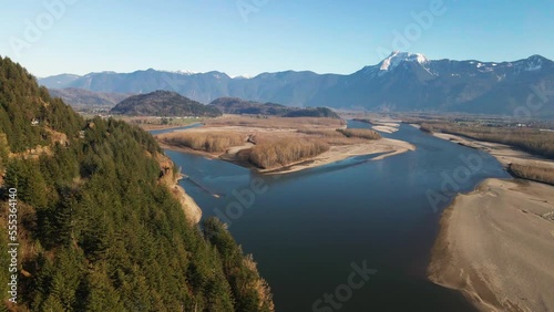 Cinematic Scene of the Fraser River Valley in the Lower Mainland in BC, Canada,  on a sunny day in autumn,  snow capped mountains, blue sky photo
