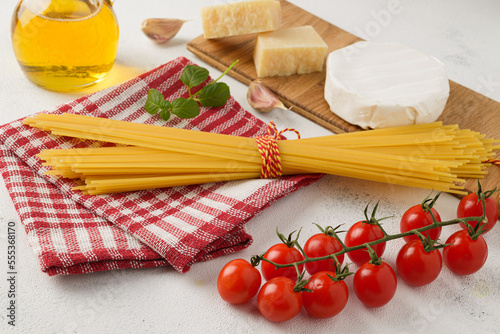 Raw spaghetti with cherry tomatoes, Camembert cheese, oil and garlic