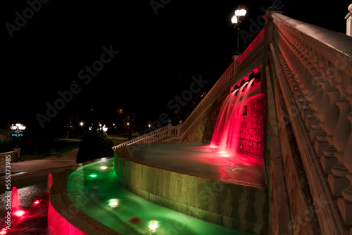 El Batallador fountain illuminated at night with intense red and green coloured lights in the José Antonio Labordeta Park or Parque Grande in Zaragoza. photo