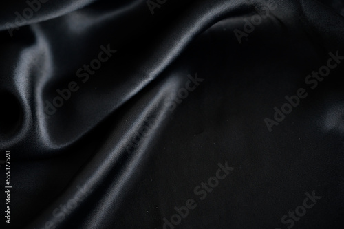 Silk background. Elegant black satin silk with waves, abstract background