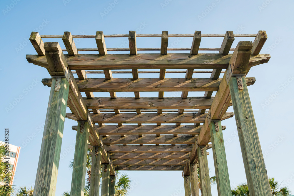 Obraz premium View of a wooden grid pergola roof from below against the sky at Destin, Florida