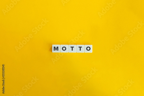 Motto Word on Block Letter Tiles on Yellow Background. Minimal Aesthetics.