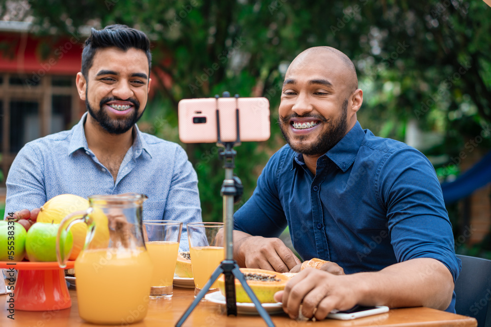 african american gay couple doing live video call outside in the garden african american gay couple doing live video call outside in the garden