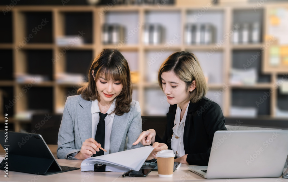Business, technology and office concept - two business women with laptop, tablet pc computer and papers having discussion in modern office. Business, technology and office concept - two business women with laptop, tablet pc computer and papers having discussion in modern office.