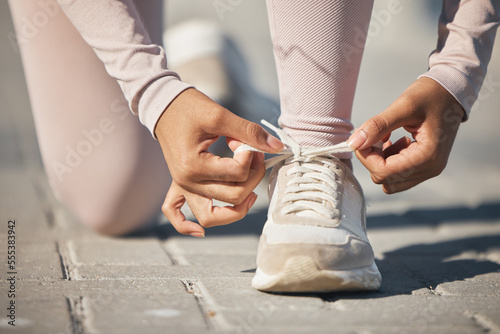 Ready, fitness and tie shoes of a woman in the street for a race, marathon or cardio running in city of Sweden. Exercise start, health and athlete laces for training motivation, sports and workout
